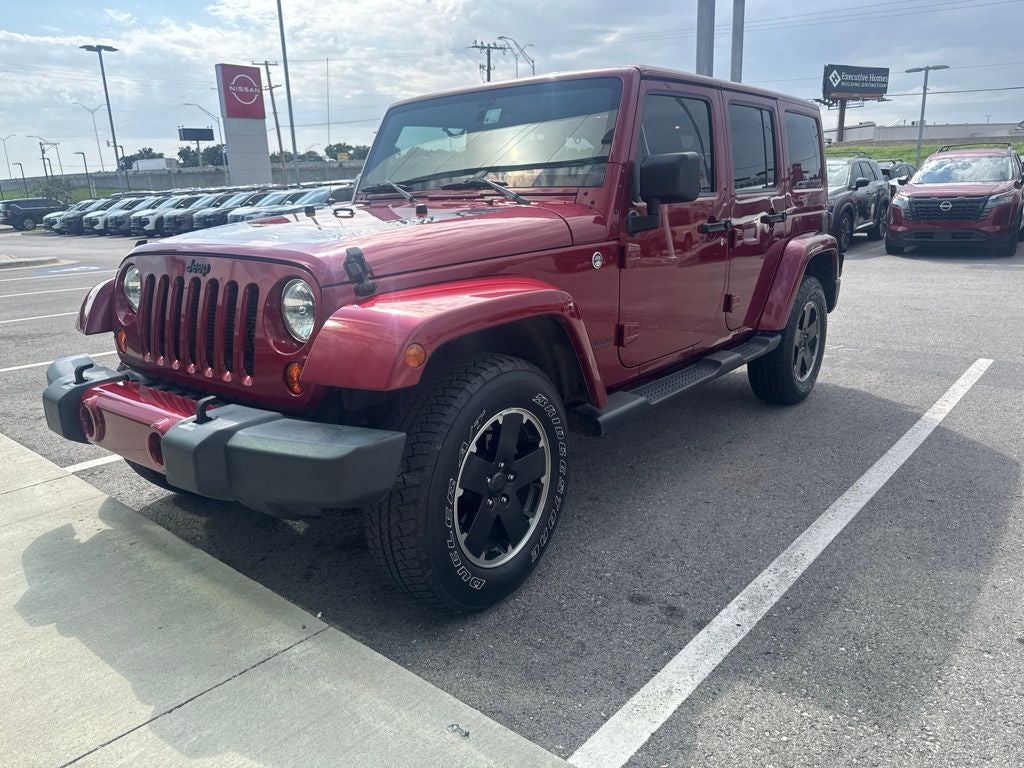 2012 Jeep Wrangler Unlimited Sahara in Maroon — front three-quarter view